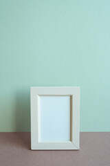 Blank picture frame on table. mint wall background. copy space