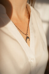 pendant in the form of a moon on a woman's neck