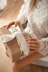 girl holding a big gift with a bow on the box
