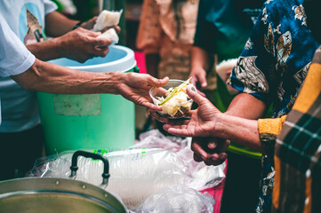 Hands of hungry beggar requesting free food from volunteers : concept of giving and sharing