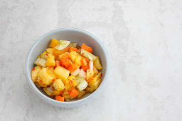 Acar or Pickles, made from diced carrot, pineapple, cucumber with chilli, vinegar, sugar, salt. 
