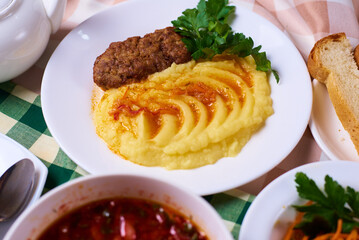 dinner set, mashed potatoes with a cutlet, a plate of soup, salad, tea and bread