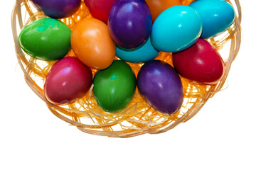 Easter tradition.multicolored painted eggs close-up in a wicker bowl on a white background.Easter food. Spring religious holiday symbol. Christian and Catholic tradition holiday.