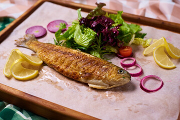 fried fish with lettuce leaves and lemon