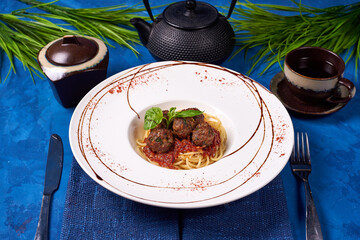 pasta with meatballs ground beef on a blue background