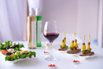 a glass of red wine on the table with a snack