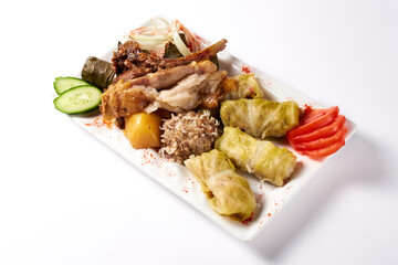 cold cuts. stuffed cabbage rolls stuffed with ground beef and rice, meatballs and lamb ribs with potatoes with fresh cucumbers and onions. on a white background