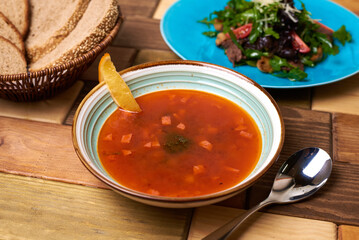 solyanka soup with lemon on a wooden background