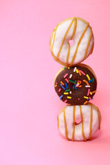 Obraz premium verity mini donuts with glaze and sprinkles on pink background 