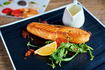 fish steak, with caviar, lemon, herbs and sauce