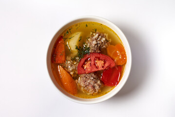 soup with meatballs in a plate on a white background