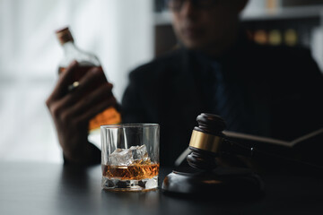 A lawyer holding a glass of whiskey, He's in his office, and he's stressing about arguing for a client, he's a lawyer. The concept of clear legal litigation.