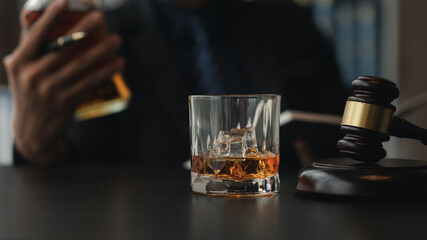 A lawyer holding a glass of whiskey, He's in his office, and he's stressing about arguing for a client, he's a lawyer. The concept of clear legal litigation.