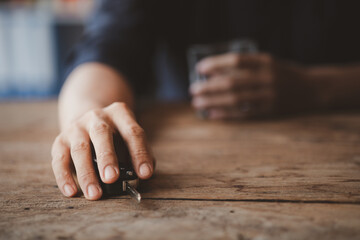 Man holding a glass of brandy, he is drinking brandy in a bar, drinking alcohol impairs driving ability and can damage health. The concept of drinking alcohol.