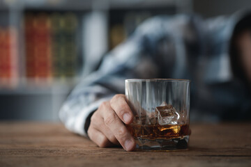 Man holding a glass of brandy, he is drinking brandy in a bar, drinking alcohol impairs driving ability and can damage health. The concept of drinking alcohol.
