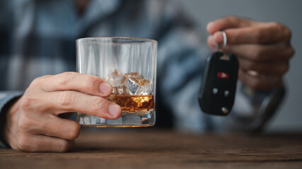 Man holding a glass of brandy, he is drinking brandy in a bar, drinking alcohol impairs driving ability and can damage health. The concept of drinking alcohol.
