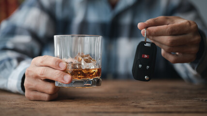 Man holding a glass of brandy, he is drinking brandy in a bar, drinking alcohol impairs driving ability and can damage health. The concept of drinking alcohol.