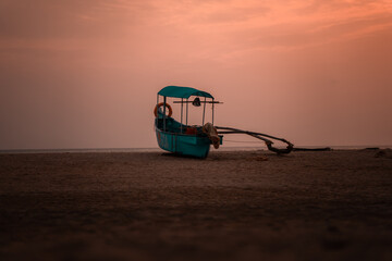 Empty Fishing boat on the empty beach during the golden evening hour