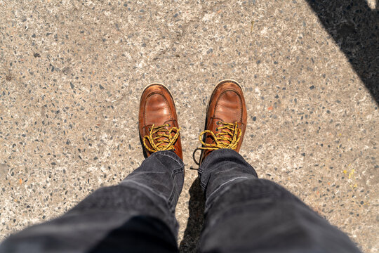 Men fashion in leather boots, Close up view on man's legs in black jeans and brown leather boots, Toned picture.