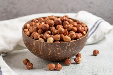 Raw hazelnuts on a gray background. Nuts in a coconut bowl. close up