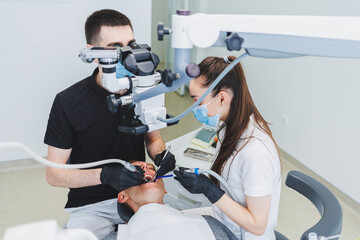 A modern dental clinic with a microscope for treating patients. A dentist uses a microscope to examine a patient's teeth. Medical equipment, dental clinic.
