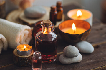 Concept of natural essential organic oils, Bali spa, beauty treatment, relax time. Atmosphere of relaxation, pleasure. Candles, towels, dark wooden background. Alternative oriental medicine - obrazy, fototapety, plakaty