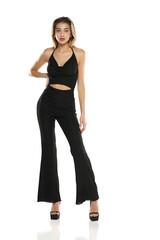 a young woman in black wide trousers and bra posing on a white background