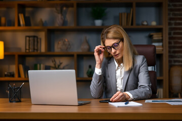 Static Portrait of Successful  Businesswoman Sitting at Her Desk Working on Laptop Computer in Office.