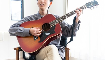 ギターを聞く若い日本人男性