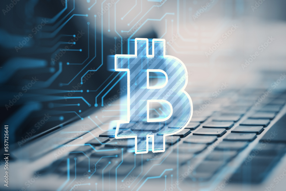 Poster close up of laptop on desktop with glowing bitcoin hologram on blurry background. digital crypto cur