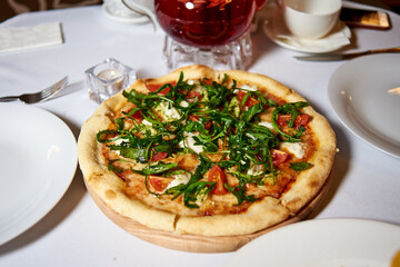 pizza with tomatoes and dandelion leaves
