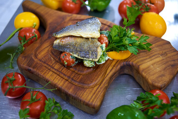 fish steak, with sauce, tomatoes and herbs