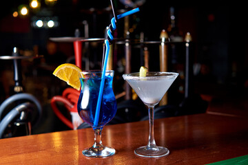 two alcoholic cocktails in the bar on the background of hookahs