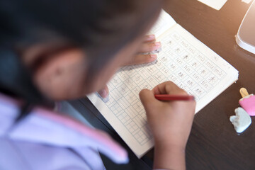 The child who is doing homework looks down and shoots