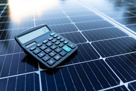 Energy saving concept with solar panels and a calculator