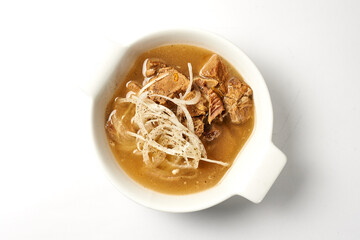 the soup with meat is sprinkled with fresh onions. on a white background