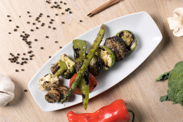 fried potato mushroom cabbage tomatoes eggplant greens on white plate