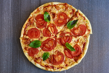 pizza with tomatoes and mint on a marble background