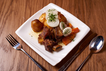 dish of cauldron kebab, in a white plate on a wooden background