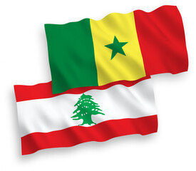 National vector fabric wave flags of Republic of Senegal and Lebanon isolated on white background. 1 to 2 proportion.