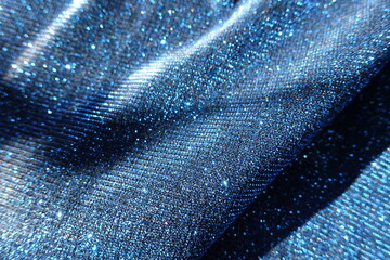 Soft folds on shiny electric blue lurex fabric