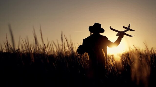 Happy girl with oy in natural park. Child runs on grass with an airplane. Chidhood dream. Happy baby girl with toy airplane at sunset. Child runs on grass in field. Dream travel concept