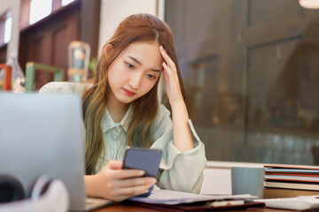 Coworking space office concept, Woman entrepreneur feeling stress while reading data on smartphone