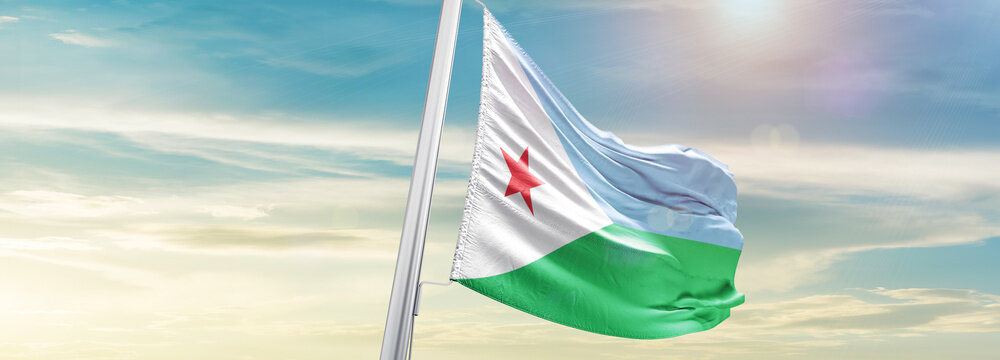 Waving Flag of Djibouti in Blue Sky. The symbol of the state on wavy cotton fabric.
