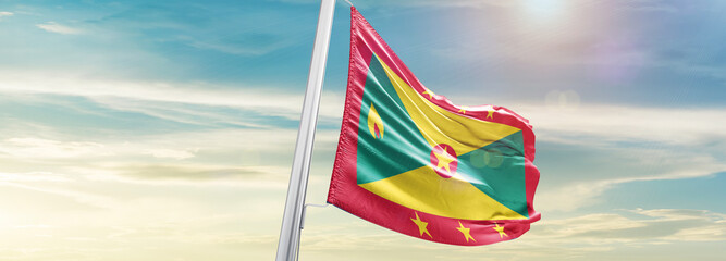 Waving Flag of Grenada in Blue Sky. The symbol of the state on wavy cotton fabric. - obrazy, fototapety, plakaty