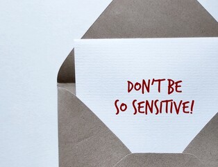 Craft envelope with handwritten message on copy space background Don't Be So Sensitive, means...