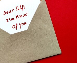 Craft envelope on red background with handwritten text on card DEAR SELF , I'M PROUD OF YOU  self-love affirmation or self awareness to boost confidence