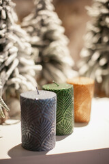 Golden green and blue color candles on the shelf of Christmas store with bokeh background