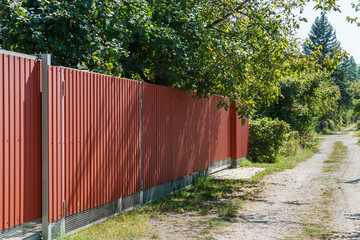 Red metal fence around private area . Metal fencing of private property in the countryside. Security concept