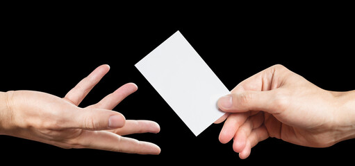Hands sharing a blank card (ticket, flyer, id card. etc.), isolated on black background